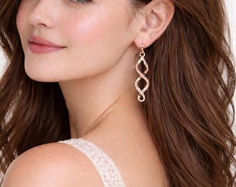Pendientes colgantes de oro rosa con diseño minimalista moderno. Joyas elegantes y ligeras para mujer.