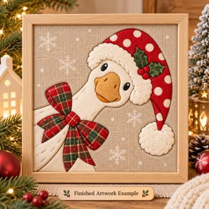 May include: A framed fabric wall art piece featuring a white goose wearing a red and white polka dot Santa hat with holly berries and a red and green plaid bow. The background is a light beige linen fabric with white snowflake patterns.
