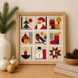May include: A square framed cross-stitch sampler featuring a grid of nine holiday-themed icons including a Christmas tree, Santa Claus, gifts, an ornament, a bird, a stocking, a candle, a snowman, and a geometric star in red, green, and yellow.