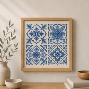 May include: A square framed cross-stitch embroidery featuring four distinct blue and white tile-inspired patterns arranged in a grid. The design displays intricate floral and geometric motifs in varying shades of blue thread on a light fabric background.