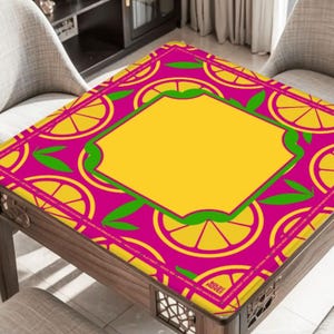 May include: A square table with a vibrant, patterned top. The design features a repeating pattern of yellow lemon slices on a magenta background, with a yellow center and green accents. The table is made of wood.