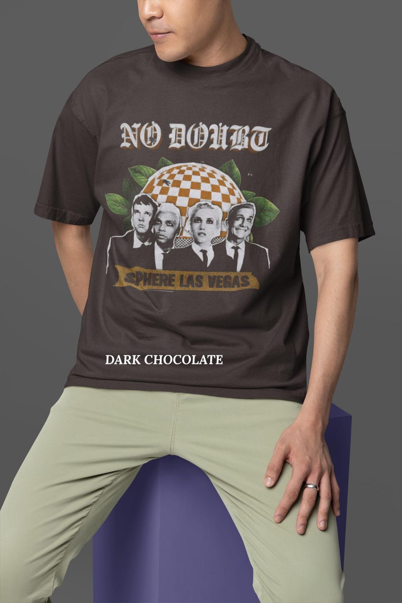 May include: Dark chocolate-colored t-shirt featuring the band No Doubt with the text "No Doubt" in a vintage font. The shirt also has the text "Sphere Las Vegas" and a checkered sphere graphic.