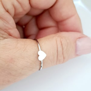 May include: A silver ring with a small heart-shaped design.