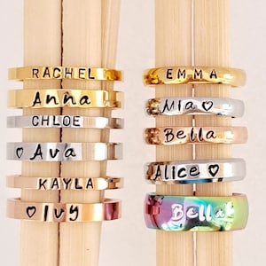 May include: A set of eight personalized rings with names including Rachel, Anna, Chloe, Ava, Kayla, Ivy, Emma, Mia, Bella, and Alice. The rings are made of different metals, including gold, silver, and rose gold.