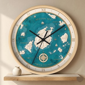 May include: Round wall clock with a light wood frame. The clock face features a map of the Aegean Sea with islands in beige and the sea in teal. Roman numerals mark the hours, and black hands indicate the time.