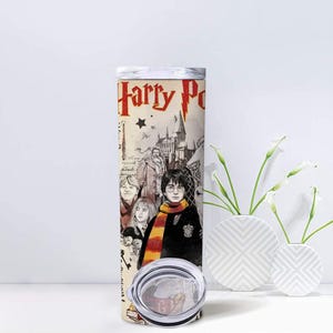 May include: A stainless steel tumbler featuring a design from the Harry Potter series. The design includes the words "Harry Potter" in red, along with illustrations of characters and Hogwarts castle. The tumbler has a silver lid and a clear base.