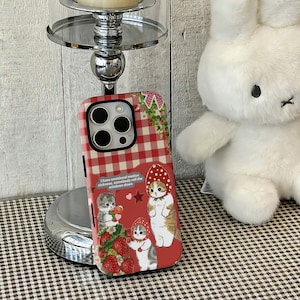 May include: A smartphone case featuring a red and white gingham pattern at the top and a red background below. The design includes three illustrated cats wearing strawberry hats, strawberries, and the text: I have emotional motion sickness, somebody roll the windows down.