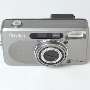 May include: A silver Rollei Prego 130 WA compact camera with a Vario-Apogon 28-130mm lens.