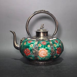 Vaso de vinho em forma de melão, em porcelana com fundo verde e motivos florais Fu, envolto em ornamentos de dragão em cobre banhado a prata.