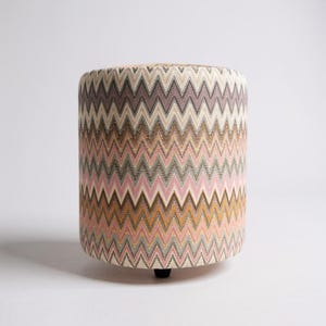 May include: A set of three ceramic mugs with a speckled, matte finish. The mugs are in shades of cream, light brown, and dark brown. Each mug has a simple, minimalist design and a rounded handle.