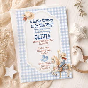 Peut inclure: Une invitation à une baby shower sur le thème du cowboy. L'invitation présente un fond vichy bleu et un cadre décoratif avec le texte "A Little Cowboy Is On The Way!" et les détails de l'événement. Une illustration de cheval de manège est également incluse.
