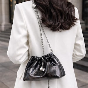 Puede incluir: Una taza de cerámica blanca con un asa negra y el texto "But First, Coffee" en negrita, en negro. La taza está sobre un fondo blanco liso. La taza mide aproximadamente 10 cm de alto.