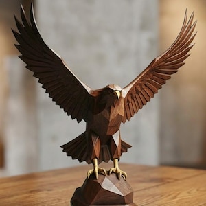 May include: A wooden sculpture of an eagle with outstretched wings. The eagle is carved from dark brown wood and has a geometric design. The eagle's talons are gold, and it is perched on a brown, geometric base.
