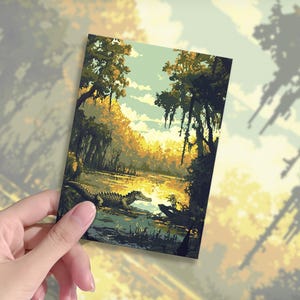 May include: A rectangular art print depicting a swamp scene with an alligator in the water. The artwork features a vibrant color palette of greens, yellows, and blues, with trees and Spanish moss. The print is held by a person.