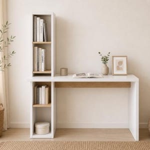 May include: A modern white desk with a built-in bookshelf. The desk has a light wood accent and is paired with a woven pouf and a potted plant. Books and decorative items are arranged on the desk and shelves.