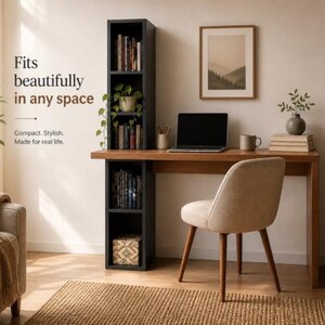 May include: A home office setup featuring a wooden desk with a laptop, mug, and books. A beige chair sits in front of the desk. A black bookshelf is attached to the desk. The text reads: "Fits beautifully in any space."