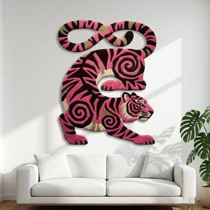 May include: A wall-mounted tufted rug shaped like a tiger, featuring a vibrant colour palette of hot pink, black, and beige. The tiger is depicted in a stylised, curled pose with intricate swirl patterns integrated into its striped fur design.