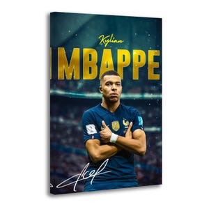May include: A vertical wall art print featuring a footballer in a dark blue jersey with arms crossed. The text Kylian MBAPPE appears in large gold letters above the player, with a white signature graphic at the bottom against a stadium background.