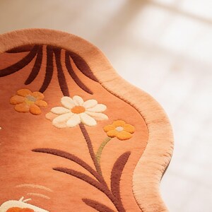 May include: A handmade wooden sign with the word "Welcome" in a playful font. The sign has a distressed white background and a dark stained wooden frame. A decorative floral element is in the corner.