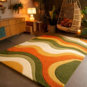 May include: A colorful area rug with a retro design. The rug features wavy stripes in shades of white, green, yellow, and orange. The rug is placed on a gray floor in a room with wooden furniture and hanging plants.