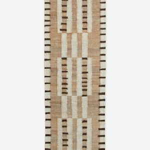 May include: A rectangular woven rug with a geometric pattern. The rug features alternating vertical stripes of beige, off-white, and dark brown. The design includes rectangular blocks of dark brown stripes. The rug is made of natural fibers.