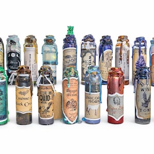 Op de afbeelding: Een verzameling decoratieve drankflessen met verschillende etiketten en waszegels. De flessen hebben etiketten met teksten als "Cascabel Scales", "Essense Black Cro" en "Unicorn Horn". De flessen zijn in verschillende kleuren, waaronder groen, blauw en rood.