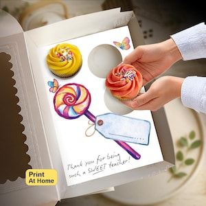 Può includere: Un inserto bianco per scatola di cupcake con un'illustrazione ad acquerello di un lecca-lecca colorato con un'etichetta regalo vuota, due farfalle e il testo "Thank you for being such a SWEET teacher!" con spazio per due cupcake, uno giallo e uno rosa.