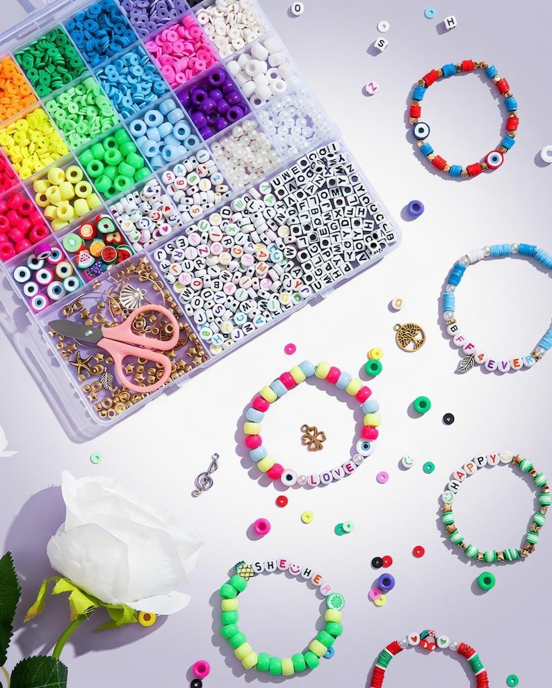 May include: A craft kit with a variety of colorful beads, scissors, and bracelets. The bracelets feature letter beads spelling out words like "LOVE" and "HAPPY". The beads are in various colors, including pink, green, blue, and yellow.