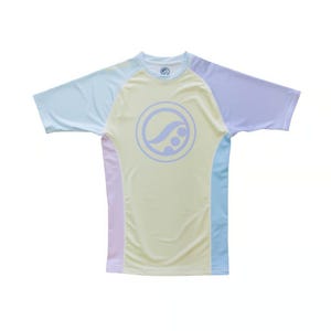 Könnte beinhalten: Ein kurzärmeliges Shirt mit Farbblock in Pastelltönen von Gelb, Blau und Lavendel. Das Shirt hat ein kreisförmiges Logo auf der Vorderseite und ist für Sportbekleidung konzipiert. Es besteht aus einem leichten, atmungsaktiven Material.