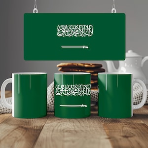 May include: Three ceramic mugs featuring the green and white flag of Saudi Arabia. The design includes the white Arabic script of the Shahada above a white horizontal sword centered on a solid green background, consistent across all three mugs.