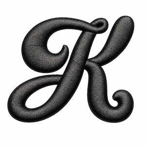 May include: A capital letter K rendered in a black, textured, three-dimensional script font. The surface of the letter features a fine, woven fabric-like pattern with rounded edges and elegant, sweeping curves that define the calligraphy style.