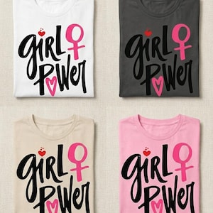 Può includere: Quattro t-shirt piegate in bianco, antracite, beige e rosa. Ogni maglietta presenta le parole "Girl Power" in corsivo nero, un simbolo femminile rosa, un cuore rosso e un cuore rosa.