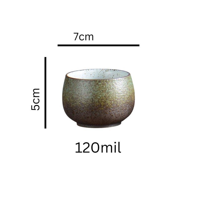 May include: A set of three ceramic mugs with a speckled, matte finish. The mugs are in shades of cream, light brown, and dark brown. Each mug has a simple, minimalist design and a rounded handle.