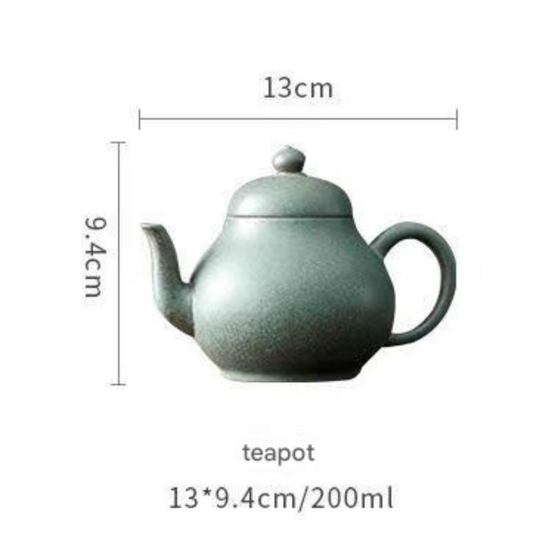 May include: A teal-colored ceramic teapot with a rounded body, a curved spout, and a loop handle. The teapot is 13 cm long and 9.4 cm high. The text "teapot" is below the teapot.