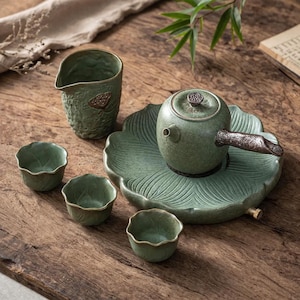 May include: A set of three ceramic mugs with a speckled, matte finish. The mugs are in shades of cream, light gray, and dark gray. Each mug has a simple, minimalist design, perfect for coffee or tea.