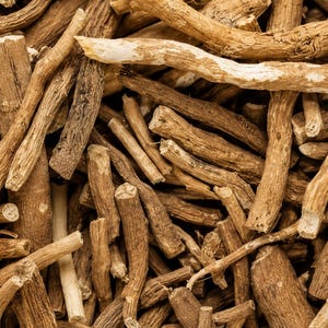May include: A collection of dried, light brown woody roots arranged in a dense, overlapping pile. The roots vary in thickness and length, featuring a rough, fibrous texture with visible bark markings and irregular, jagged ends throughout the cluster.