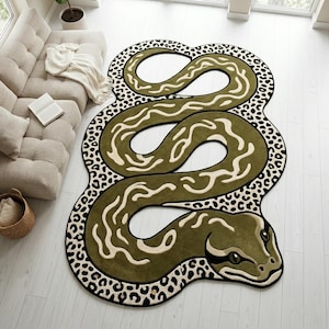 May include: A large, olive green snake-shaped rug with a cream-colored pattern and a black and white leopard print border. The rug features a detailed snake head and body, perfect for a living room or bedroom.
