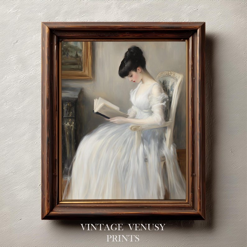 May include: A framed vintage print featuring a woman in a white dress reading a book while seated in a chair. The print has a dark brown wooden frame and the text "VINTAGE VENUSY PRINTS" at the bottom.