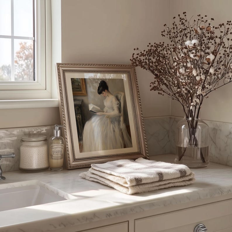 Seated woman reading artwork poster for bedroom — elegant white dress in soft hues evokes a serene, timeless atmosphere.