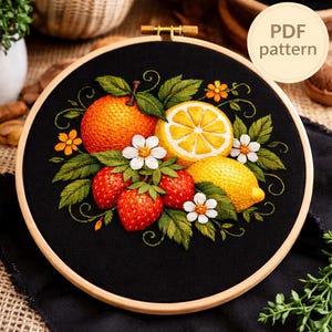 May include: Embroidered fruit design on black fabric, featuring an orange, lemon, strawberries, and flowers. The design is set in a wooden embroidery hoop. The text "PDF pattern" is visible in the upper right corner.