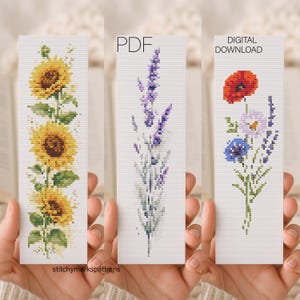 Könnte beinhalten: Drei Kreuzstich-Lesezeichen mit floralen Designs. Eines zeigt Sonnenblumen, ein anderes Lavendel und das dritte eine Mischung aus rotem Mohn, blauen und lila Blumen. Der Text "PDF" und "DIGITALER DOWNLOAD" ist auf zwei der Lesezeichen zu sehen. Das Wasserzeichen "stitchymarkspatterns" befindet sich unten.