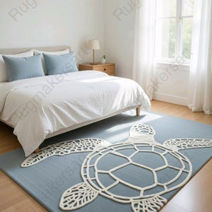 May include: A blue rectangular rug with a white turtle design in a bedroom setting. The turtle's outline and details are created with a thick, textured white material. The rug is placed in front of a bed with white bedding and blue pillows.