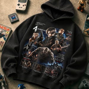 Könnte beinhalten: Ein schwarzer Kapuzenpullover mit einem Resident Evil 4 Grafikdruck. Das Design zeigt die Charaktere Leon S. Kennedy, Ashley Graham und verschiedene Gegner, wobei Texte wie 'Resident Evil', 'El Gigante' und 'Los Iluminados' sichtbar sind.