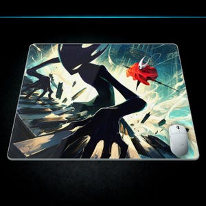 May include: A rectangular desk mat featuring a vibrant digital illustration of a large, dark, shadowy figure with glowing eyes looming over a crumbling stone structure, while a small, white-masked character in a red cloak leaps through the air.