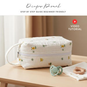 May include: A white diaper pouch with a zip closure and a handle. The pouch is decorated with small, colourful animal and plant designs. A dummy and a wooden teether are next to the pouch. Text on the image reads "Diaper Pouch" and "Step by Step Guide Beginner Friendly."