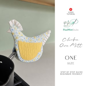 May include: A chicken-shaped oven mitt with a yellow quilted pocket and a floral pattern in blue and yellow. The mitt has a white ruffled trim and is hanging on a pot. The text "Chicken Oven Mitt" is visible.
