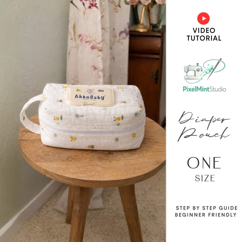 May include: A white diaper pouch with a zipper closure and a handle, adorned with a pattern of small yellow and green designs. The pouch has a label that reads "AkkoBaby". It is placed on a small wooden table.