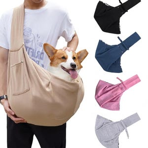Pode incluir: Uma bolsa de transporte para animais de estimação bege com um bolso, segurando um cão corgi. Transportadoras adicionais em preto, azul marinho, rosa e cinza são mostradas. A bolsa tem uma alça de ombro para facilitar o transporte.