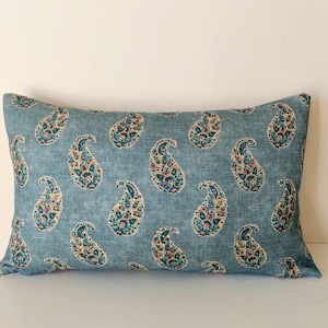 May include: A blue throw pillow with a paisley pattern in shades of pink, teal, and brown.