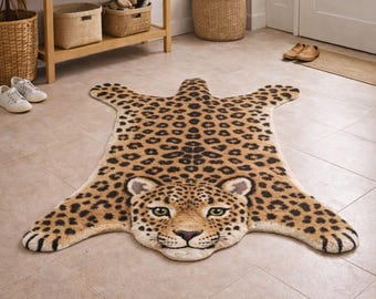 May include: A decorative leopard-print rug with a detailed face and spotted pattern. The rug is tan with black spots and green eyes, designed to resemble a leopard skin. The rug is placed on a tiled floor.